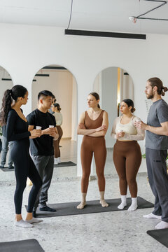 People listening and looking at asian man in fitness studio