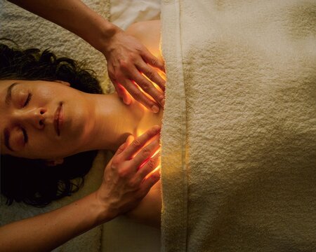 Woman Receives Treatment While Laying on Soft Towels in Spa