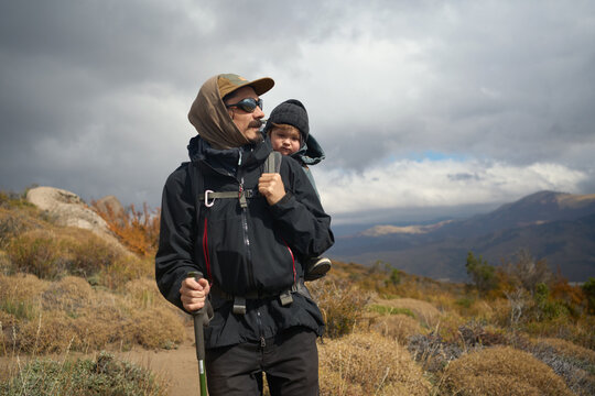 Dad Hikes With Child in the Mountains on a Cloudy Day