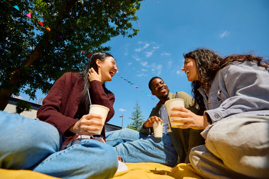 Friends Relaxing at Outdoor Festival with Drinks