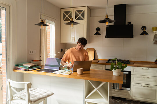 Working at a Kitchen Table With Laptops and Papers in the Morning
