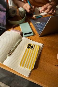 Student Working at a Wooden Table With Notebooks 