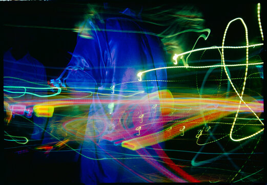 Colorful Light Trails at a Night Event With Moving Figures