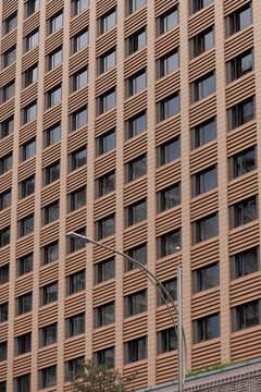 Brown geometric architecture with diagonal lines and a streetlight