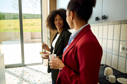 Colleagues Share Food and Drinks in a Bright Kitchen