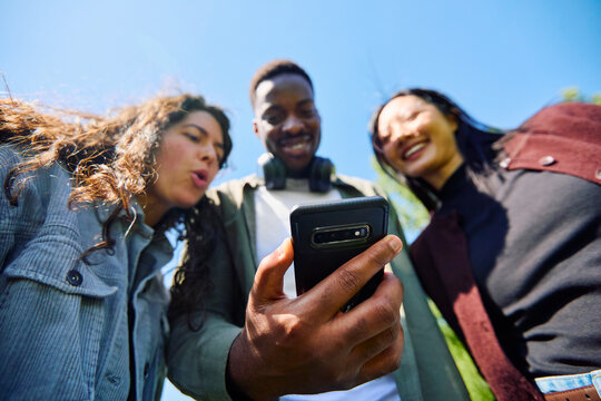 Friends Looking at Phone Outdoors