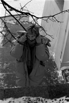 B&W Film Photo of Young Woman Bundling Up in Winter Cold
