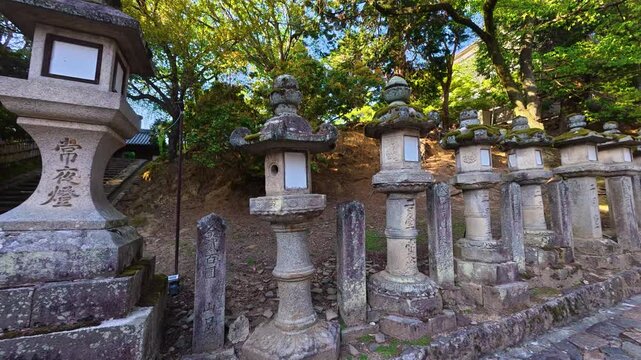 Traditional stone lanterns line a pathway in the famous ancient city of Nara, the former first capital of Japan during the Nara period from 710 to 784. Stone lanterns, called toro, are sacred.