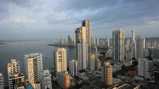 Golden hour light illuminating the modern skyscrapers and high-rise buildings of the bocagrande district skyline in cartagena de indias, colombia, overlooking the caribbean sea