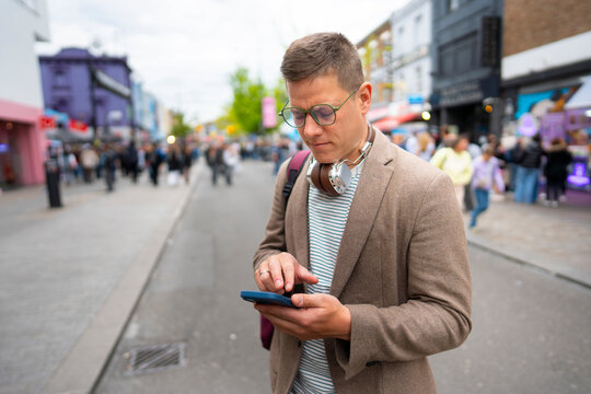 Man checking smartphone in crowded street