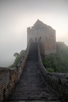 Steep stone path to a foggy watchtower
