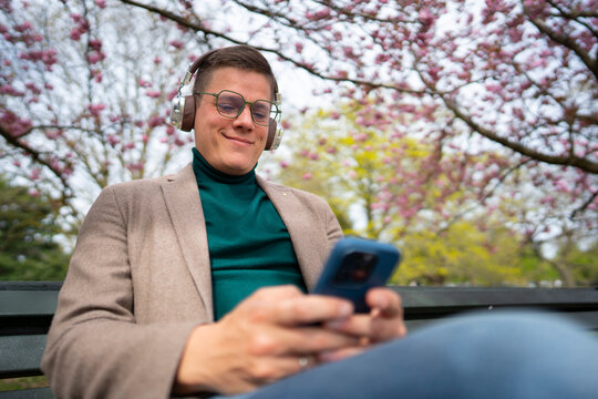 Man using smartphone on bench in park