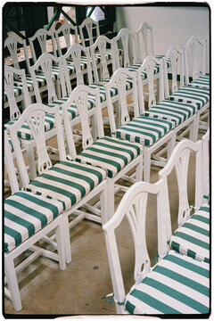 Several chairs with green-striped cushions arranged in rows