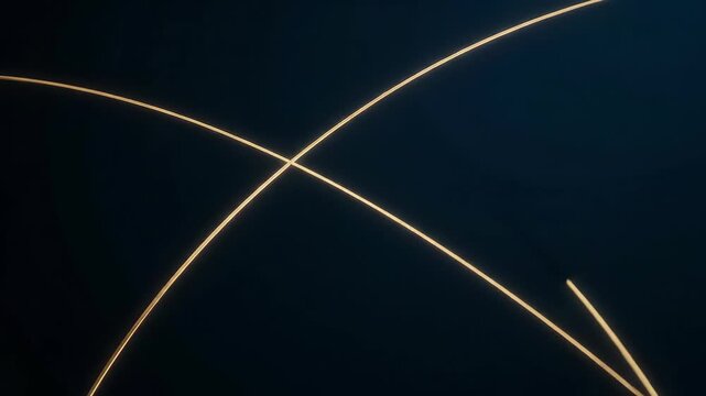 Glowing golden lines intersecting in dynamic motion against deep blue-black void. Perfect for tech branding, futuristic visuals, cinematic transitions
