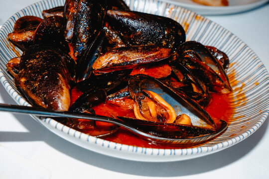 a bowl of Spanish mejillones a la marinera on a restaurant table