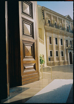 Open doorway facing a sunlit stone building