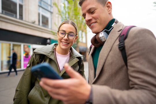 Tourists smiling while checking directions on phone