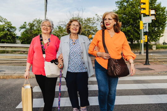 Senior women friends walking together enjoying urban life