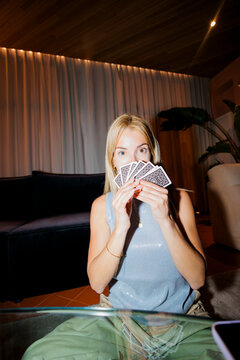 Woman holding cards at home enjoying game time