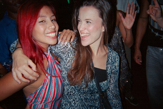 Two girlfriends posing for picture in nightclub