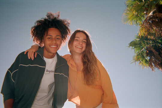 Two friend looking at camera in backlight over blue sky. Film. UGC