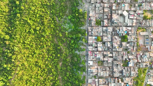 Top down drone shot of dense city infrastructure and poor city planning . Encroachement upon vulnerable natural habitats.