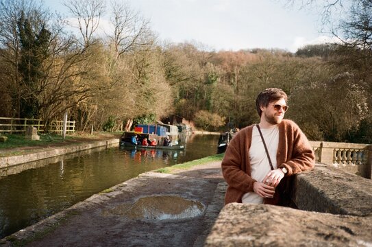 A Man Enjoys Sunny Day by Canal in Rural Area