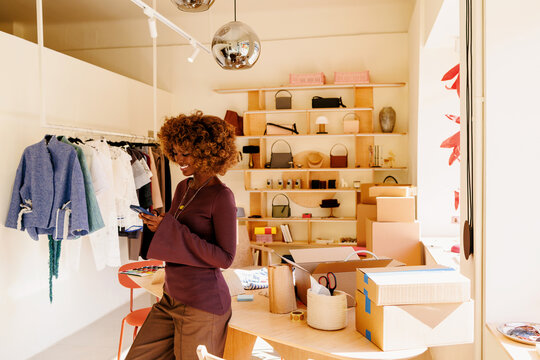 Woman using phone in stylish store