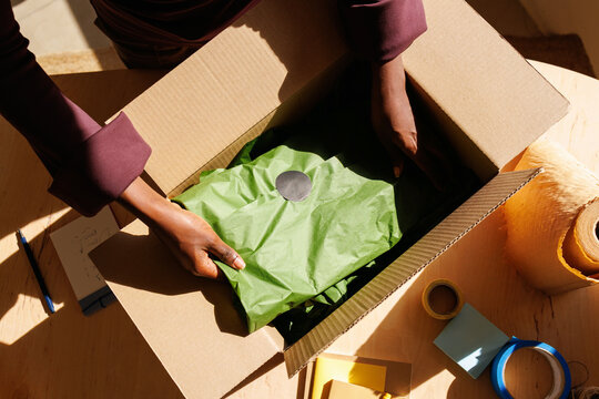 Woman packing items in cardboard box