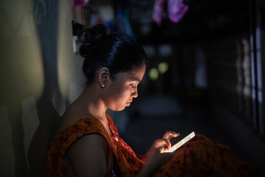 Young Indian woman browsing smartphone at night