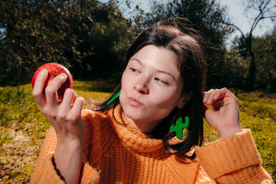 Young Japanese woman eating an apple outdoors
