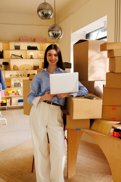Portrait of a woman with laptop in small business ecommerce workspace