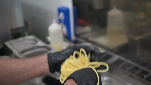 un chef nella cucina di un ristorante prepara gli spaghetti con le mani