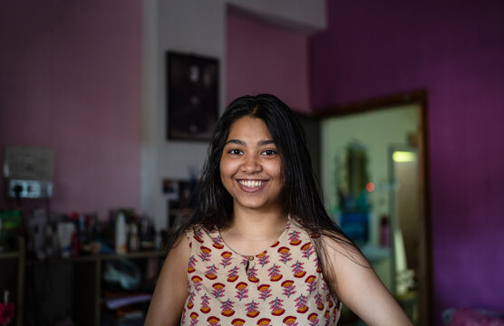 Young Indian woman smiling inside home