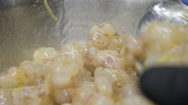 condimento di un piatto di pasta con una tartare di mazzancolle fresche, nella cucina di un ristorante di mare