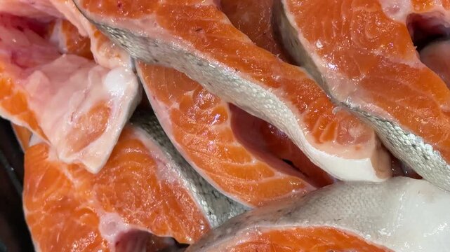 Steaks of chilled Atlantic salmon from frozen raw materials on a substrate for sale in a supermarket. Close-up