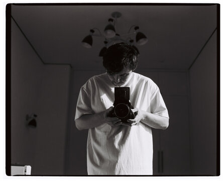 Man Taking Self Portrait with Medium Format Camera Indoors