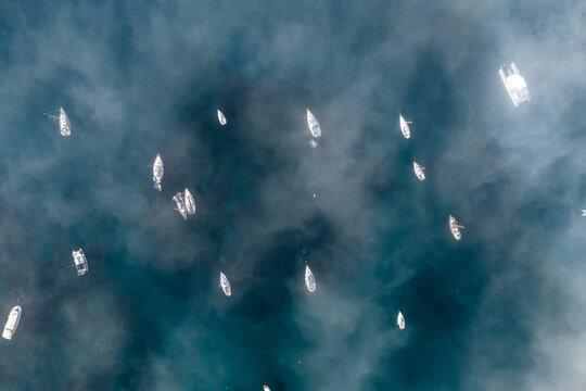 Boats anchored in the sea in a Calm Sea With Fog in morning, top down