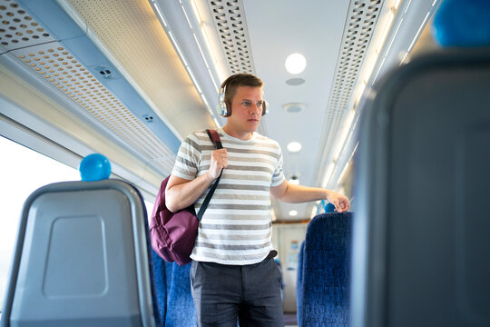 Passenger standing inside modern train carriage