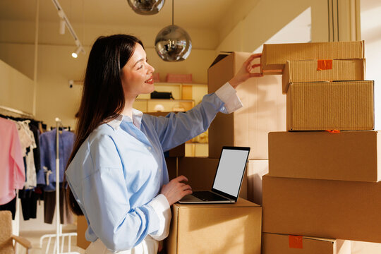 Woman Entrepreneur Using Laptop in Ecommerce Workspace