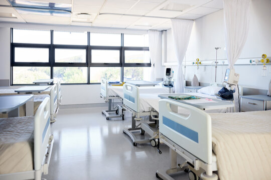 Hospital Room With Many Empty Beds and Windows