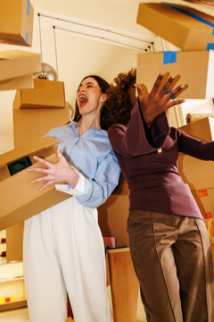 Business colleagues throwing boxes in office environment