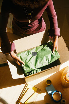 Woman packing order at desk small business film photo