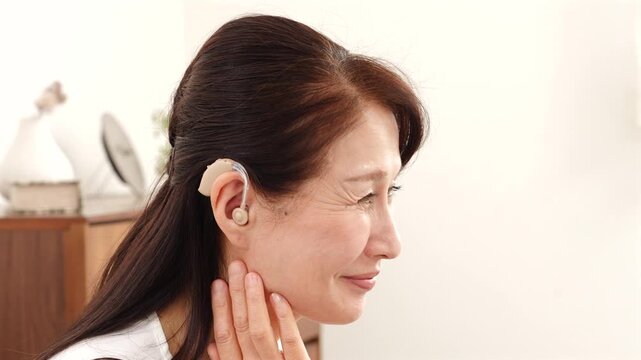 補聴器を付けたシニア女性　リビング