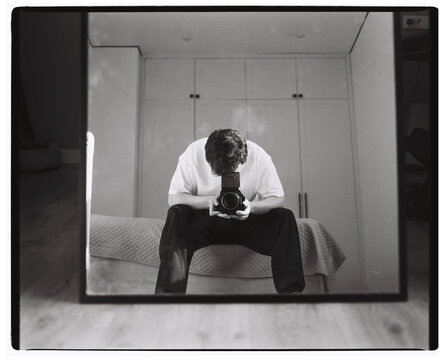Man Taking Self Portrait with Medium Format Camera Indoors