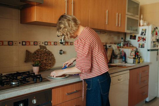 Woman cutting food on kitchen counter at home