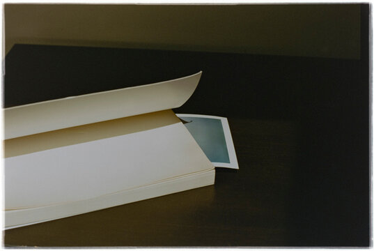Book With Photo Print on Dark Table