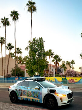 Chandler, Arizona, USA - May 8, 2026: A Waymo self driving taxi vehicle parked on the street Chandler during golden hour in the Phoenix metropolitan area.

