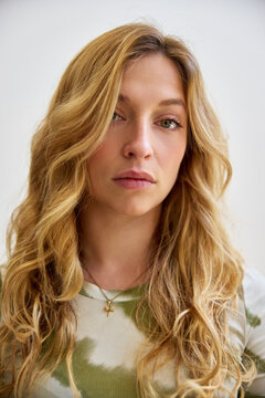 Portrait of a woman with long hair against a plain background