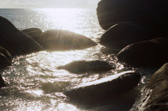Water flows over large rocks along the shore